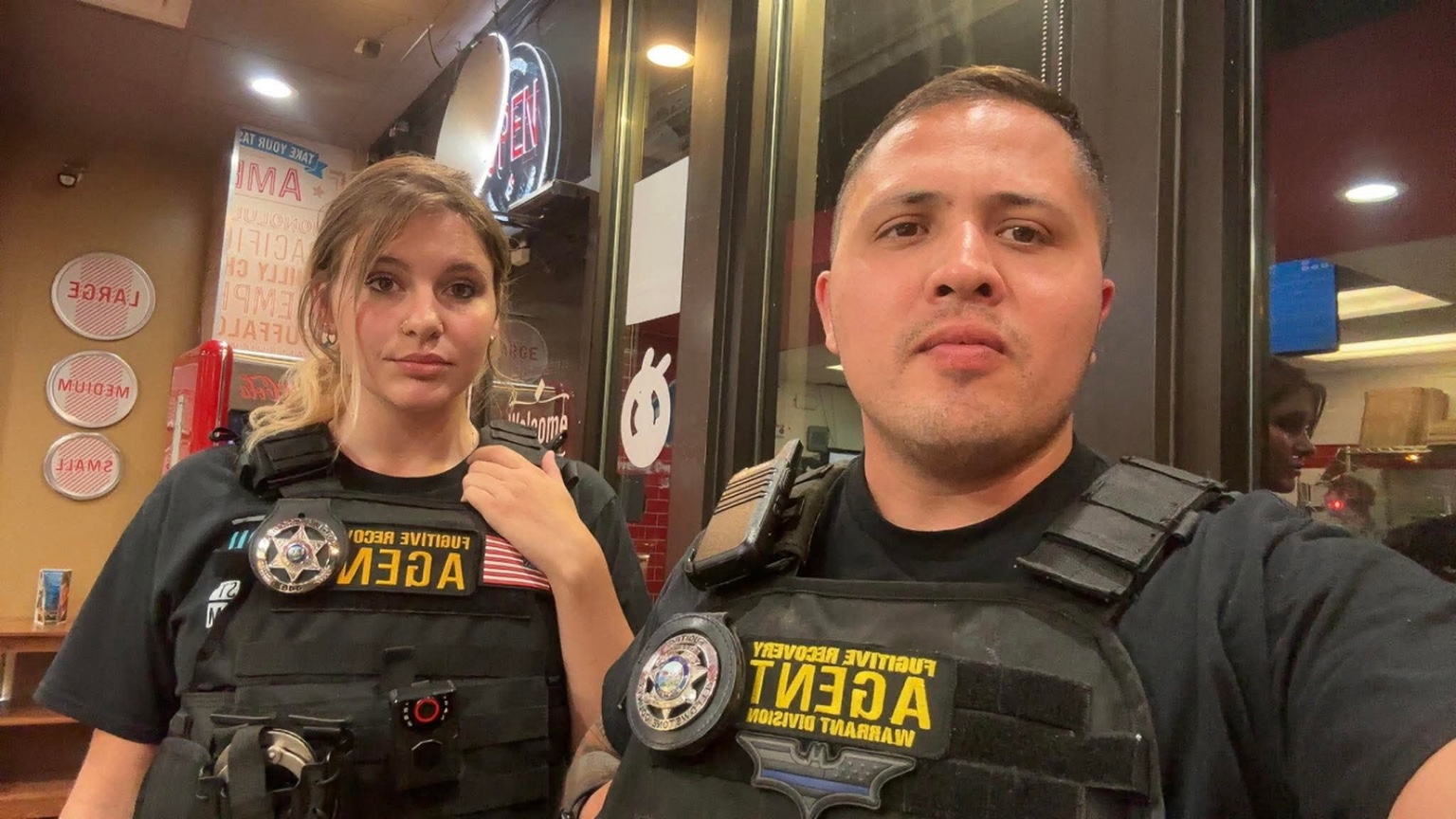 Two fugitive recovery agents wearing field vests during work in Montana.